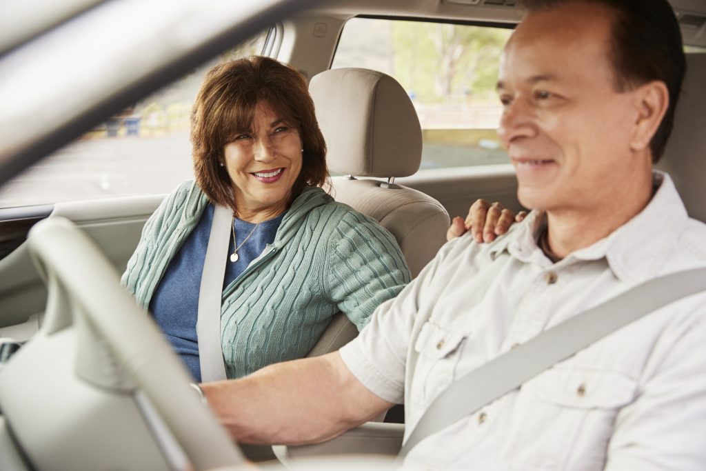 Woman passenger smiling at the driver during car road trip